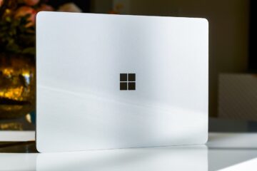A white laptop sitting on top of a table