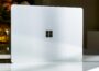A white laptop sitting on top of a table