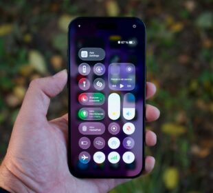 Hand holding a smartphone with colorful app icons.