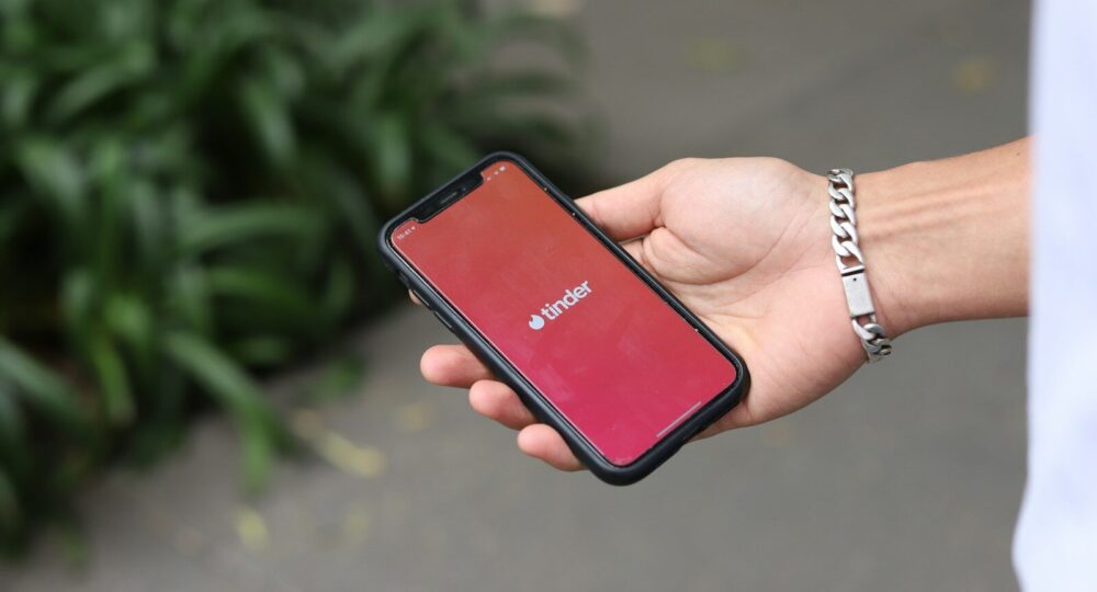 a person holding a red cell phone in their hand