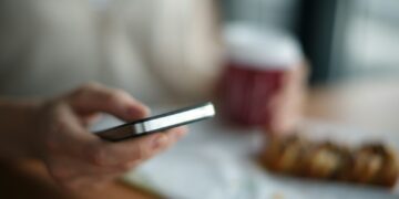 selective focus photography of person holding gray phone