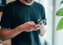 man in black crew-neck top using smartphone
