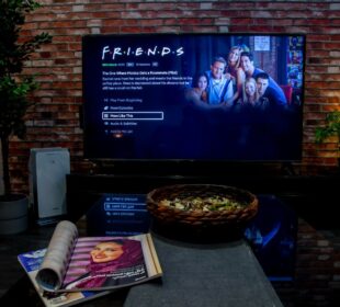 black flat screen tv turned on near brown brick wall