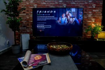 black flat screen tv turned on near brown brick wall