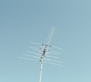 black electric post under blue sky during daytime