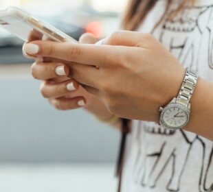 woman holding iPhone during daytime
