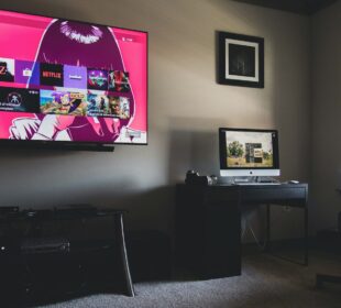 black flat screen tv turned on near black wooden table