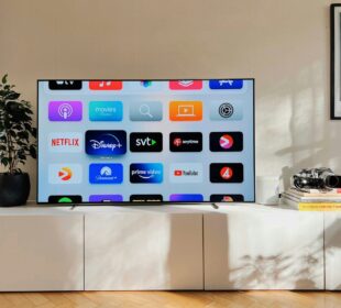 a flat screen tv sitting on top of a white cabinet