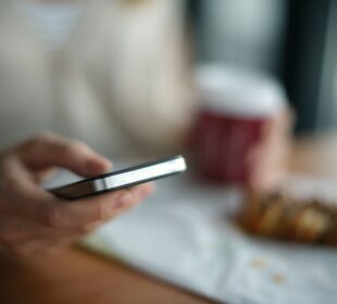 selective focus photography of person holding gray phone