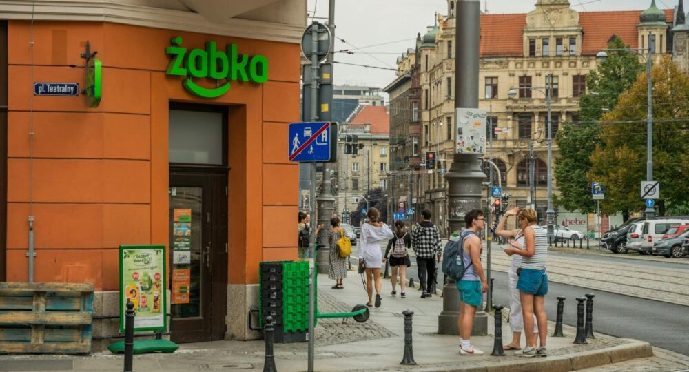Urban street view in Wrocław, Poland, featuring people, cafes, and bustling city life.