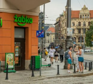 Urban street view in Wrocław, Poland, featuring people, cafes, and bustling city life.
