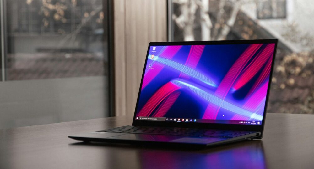 a laptop computer sitting on top of a wooden table