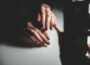 A woman's hands resting on a piano