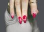 selective focus photography of woman's pink manicure