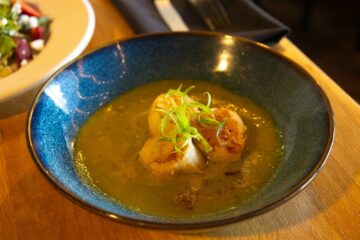 Scallops in a greenish broth with garnish