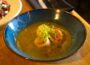 Scallops in a greenish broth with garnish