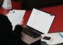 A person sitting at a desk with a laptop and papers