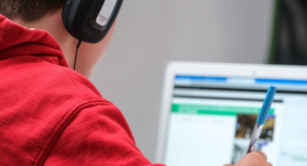 person in red shirt wearing black and gray headphones