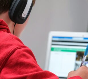 person in red shirt wearing black and gray headphones